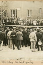 A large group gathers at a building dedication and listens to a speaker. Written on recto: (Miss) Amy Chadwick speaking - May, 1926