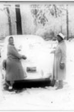 Ruby D. Smith stands in the snow next to a car with another young woman.