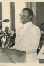 Fred Shuttlesworth is shown speaking at an event to mark the 20th anniversary of the signing of the 1964 Civil Rights Act. Written on verso: The former president of the Birmingham-based Alabama Christian Movement for Human Rights, Rev. Fred Shuttlesworth, speaks at the 20th Anniversary Observance of the signing of the 1964 Civil Rights Act. Rev. Shuttlesworth is an SCLC Board Member. (7/2/84)