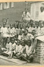 A group of Chadwick School pupils sit on the steps of the school.