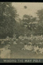 "Winding the May Pole," Children sitting in field at outside event.