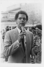 Julian Bond speaks at a rally to protest the United States' veto of a United Nations resolution condemning the South African invasion of Angola. Written on verso: South Africa -- Georgia State Senator Julian Bond says black Atlantans must begin to help determine the direction U.S. policies will take in South Africa, as he speaks before a rallying crowd protesting the South African invasion of Angola.