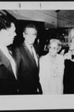 Maynard Jackson, Julian Bond, an unidentified woman, and Carolyn Long Banks talk at a reception.