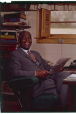 Benjamin E. Mays sits behind his desk in his office.