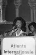 Vivian Malone Jones speaks from an "Atlanta Internationale" podium at an event.