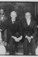 George A. Towns and others sit on steps. Written on verso: back row; G. A. Towns, M. W. Adams, E. H. Webster, Miss M. D. Hancock; Miss L. A. P[er]igree , Miss I. M. Swift