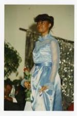 View of woman wearing a blue dress. Written on verso: "Miss Janet Curtis; 2nd Attendant to Miss Morris Brown College; 1985-86".