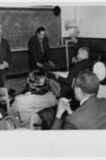 Langston Hughes and Arna Bontemps give a lecture. Written on verso: Langston Hughes to right facing group Atlanta University - March 28, 1947, Also - Arna Bontemps of Fisk