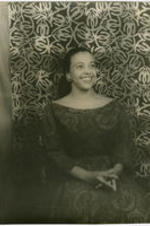 Portrait of Adele Addison seated in front of a patterned background. Written on verso: Photograph by Carl Van Vechten; 146 Central Park West; Cannot be reproduced without permission; April 8, 1955.