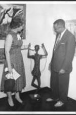 Mrs. G. Foster and Jack Jordan look at his prize-winning sculpture, "Negro Girl Skipping Rope".