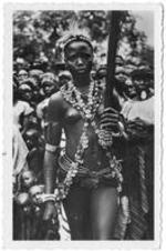 An African woman in dance dress. On verso (translated from French): Witch doctor dressed in dance.