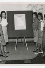 Indoor group portrait of  women with display board "Student Teaching Centers of Georgia".
