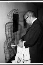 Dr. Bond looks at a sculpture titled "Woman with Brassier".