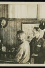 Four unidentified men examining a machine.