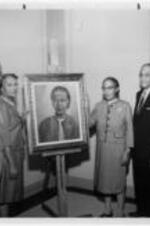 Frankie V. Adams and others pose with a painting of Mrs. Simon. Written on verso: Schools Mr. Coleman, Mrs. Jewel Simon, Miss Frankie Adams, Dr. Clement and Dean Jackson�Mrs. Simon painted the portrait of Miss Adams for the School of Social Work alumni.