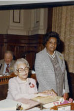 Grace Townes Hamilton at her desk with and unidentified woman with a visitor pass at the Georgia House of Representatives.