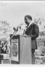 Ralph D. Abernathy is shown speaking at the March For Jobs and Justice event held outdoors at The King Center. Written on verso: SCLC president emeritus, Rev. Ralph D. Abernathy, recalls the historic day when founding SCLC president Martin Luther King, Jr. made his soul shaking speech to America.