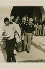 Alabama State Troopers are shown blocking the entrance to Murphy High School to turn away Dorothy Bridget Davis and Henry Hobdy as part of George Wallace's executive order. Caption on photo reads: (MOB2) MOBILE, ALA., Sept. 9 - TROOPERS TURN BACK STUDENTS - With Alabama State Troopers blocking the main entrance to Murphy High School, Negro students, arms loaded with school books, Dorothy Bridget Davis, 16, and Henry Hobdy, 17, turn away from school. Hobdy is reading his copy of an executive order from Governor Wallace stopping the pair from attending classes. Murphy high is Alabama's largest high school with 3,300 students.