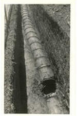 A sewer line uncovered while building the central power plant for the Atlanta University Center. Written on verso: Showing condition of 18" sewer in ric. Wil. Line, view looking south between manholes #4 and #5