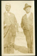 Two unidentified men standing outside.