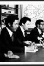 Maynard Jackson sits on a panel with other unidentified men.