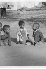 Children play on a playground. Written on verso: children of campus families (L to R): Kay and Deon Jones, Wm. Meekins Jr., Norman Jones and Billy Shields.