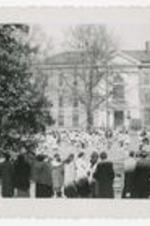 Outdoor view of a crowd on a campus lawn.