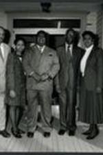 C. Eric Lincoln and Dr. John Hope Franklin stand on a porch with other unidentified men and women.