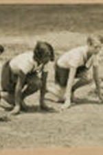 Four girls crouch at a track starting line.
