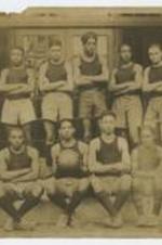 Outdoor group portrait of young men wearing athletic wear, one man holding a basketball.