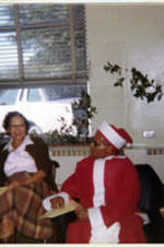 Dr. Copher sits next to Mrs. Copher in a Santa suit. Written on rector: Dr. and Mrs. Copher.