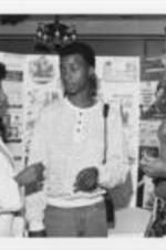 Brenda Davenport is shown speaking with a college student (center) at an unknown event. Written on verso: Youth Leaders -- Brenda Davenport, SCLC's Youth/Student Director and a graduate of Shaw University is joined by Kim Miller, Associate Director and graduate of Howard University, in stressing the importance of black colleges to _____ _____.