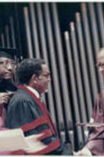 Joseph E. Lowery shakes hands with Dr. Hugh Gloster as he receives an honorary degree during Morehouse College's commencement ceremony. Dr. Wildon Jackson is at far left in the photo.