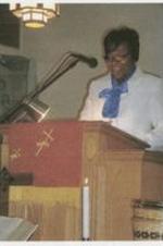 Dr. Lewis speaks to the congregation from behind a podium. Written on verso: Dr. Francena Lewis.
