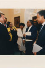 Joseph E. Lowery stands in a room at the White House with Vice President Al Gore, Reverend Jesse Jackson, and others.