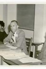 President Hugh Gloster sitting next to unidentified persons. Written on verso: Dr. Hugh Gloster, consultant in the English Workshop. Annual Career Conference, Wednesday, November 5, 1958.
