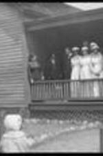Women and nurses gather with children outside of the neighborhood house.