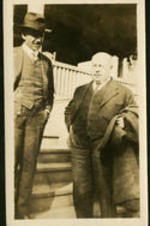 Two unidentified men standing on a porch.
