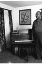 C. Eric Lincoln stands next to his piano in his home.