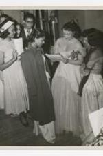 A woman signs an audigraph for a young woman backstage.