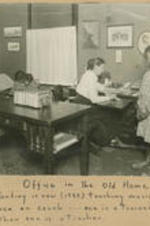 Interior of the office with a woman and tree girls. Written on recto: Office in the old home. Girl standing is now (1933) teaching music in Chicago. Children on couch - one is a trained nurse, the other one is a teacher.