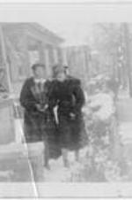 Anna E. Hall standing outside with a woman in winter. Written on verso: Miss Anna E. Hall, Mrs. Joseph J. Dennis (Sammye).