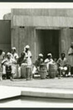 View of men playing drums outside a building.