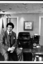Maynard Jackson sits on a desk in his mayor's office.