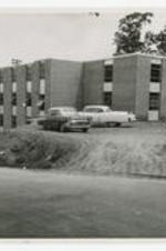 View of William R. Wilkes Hall with cars in the foreground.