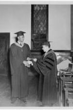 Dr. Harry Richardson awards a man a diploma and shakes his hand during commencement. Written on verso: Reverend Clifton N. Bonner, 1953 graduate of Gammon, received award from president Harry V. Richardson for outstanding achievements during his three years as a student at Gammon.