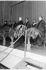 James P. Brawley stands on stage with others during a ceremony.