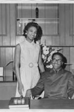 John H. Ruffin, Jr., and Judith Ruffin pose behind a desk. Written on verso: Judith Pearlene Fennell Ruffin; John H. (Jack) Ruffin, Jr.; Open House; Law Offices of John H. Ruffin, Jr. 1101 11th St. Augusta, GA; Nov. 22, 1970 (Relocation)