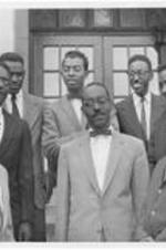 A group of students stand outside a building. Written on verso: Gammon Theological Seminary Officers of the 1959 Student Christian League: Reading from left to right front row: Granville Hicks, Lenton H. Powell, Oswald P. Parson and Edward T. Gibson. Back row: Raymond T. Gibson, Cornelius Henderson, Norman W. Stevenson and John L. Preciphs.
