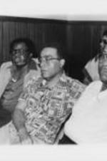 Southern Christian Leadership Conference (SCLC) members N.Q. Reynolds, Chauncey Eskridge, and Matthew Moore are shown sitting during an event at the 23rd Annual Southern Christian Leadership Conference (SCLC) Convention in Cleveland, Ohio. Written on verso: Reynolds, Chauncey Eskridge, Moore - Cleveland, '80